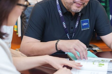 Two professionals from LRQA review a document together during a focused meeting.