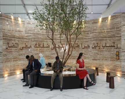 People sitting under a tree in an entrance area